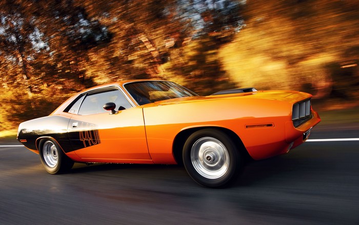 Orange Plymouth Barracuda 440 driving on a road