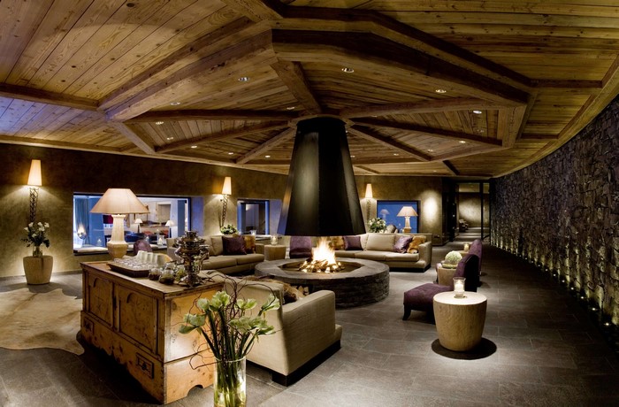 Luxury living room with a central fireplace and wooden ceiling