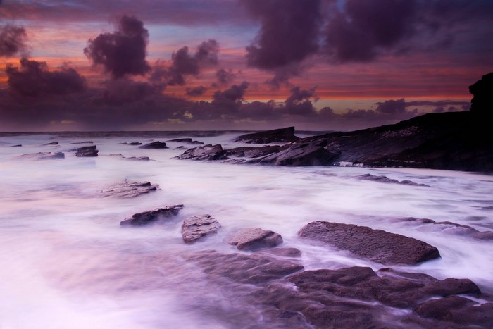 Sea stones and dramatic clouds at sunset