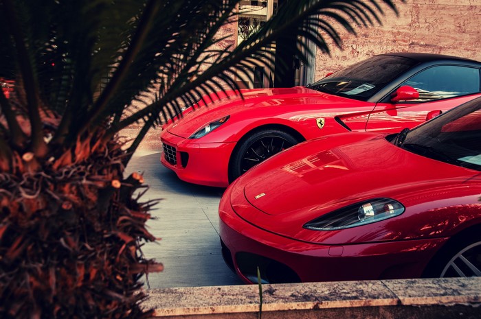 Two red Ferraris parked outside