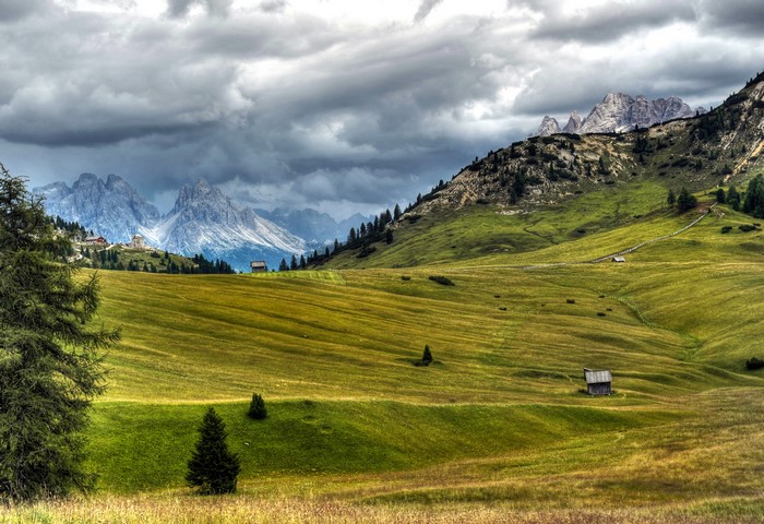 Dolomites Mountains in Italy with Green Grasslands and Clouds