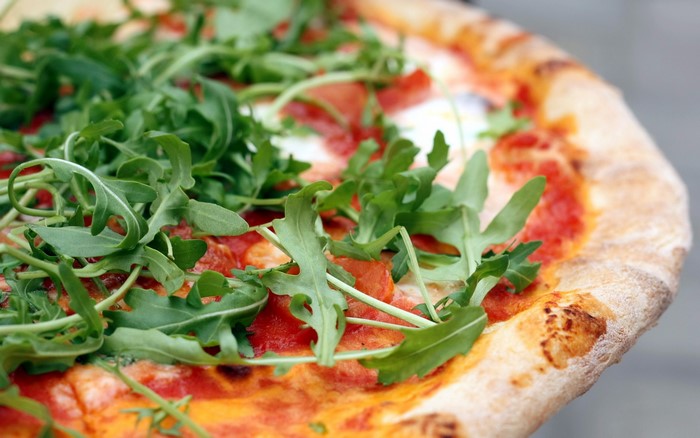 Pizza with arugula and tomato sauce