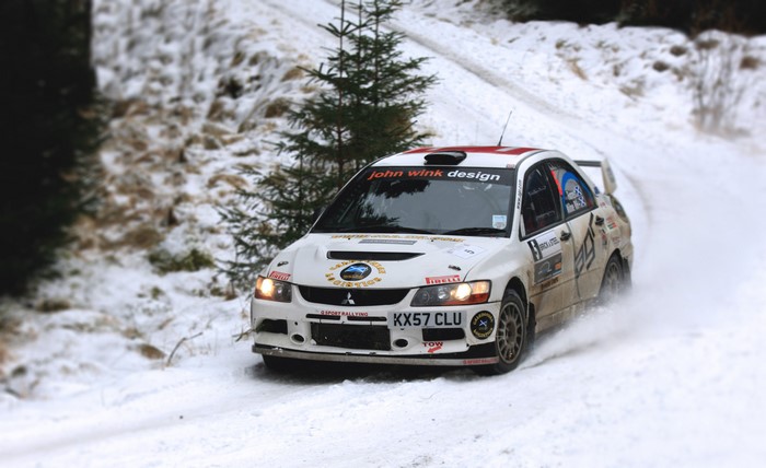 Mitsubishi Lancer rally car driving in snow
