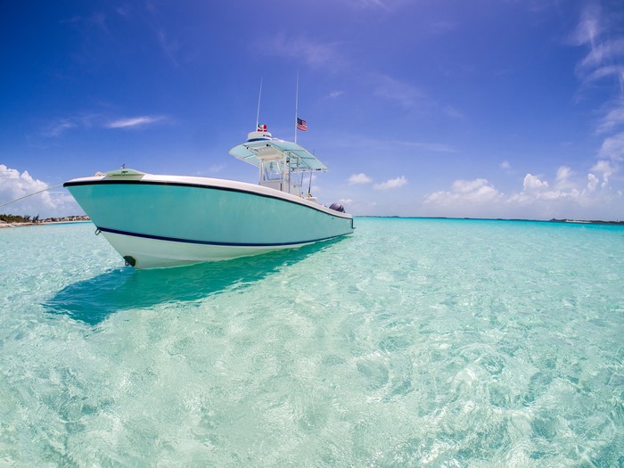 Boat on clear turquoise water under blue sky