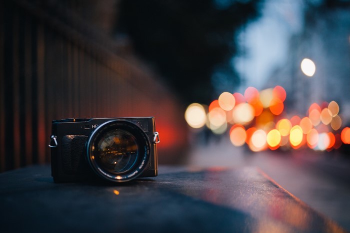 Camera on a dark surface with bokeh lights