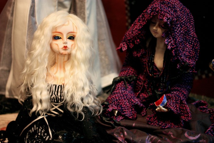 Two dolls, one with blonde hair, the other with a purple hood