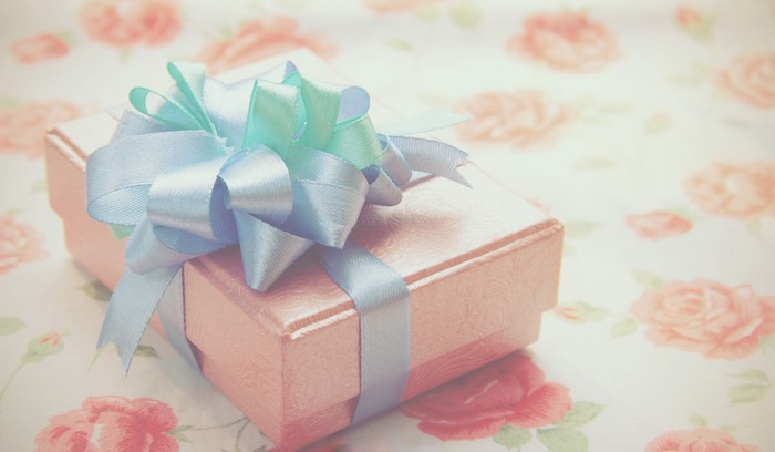 Pink gift box with blue and green ribbon bow