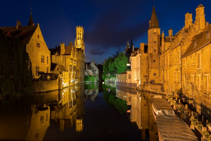 Bruges canal at night with historic buildings and reflections
