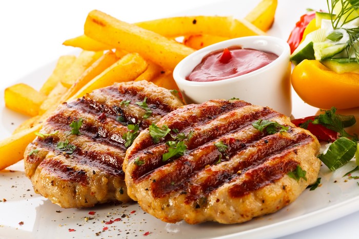 Grilled meat patties with french fries and ketchup