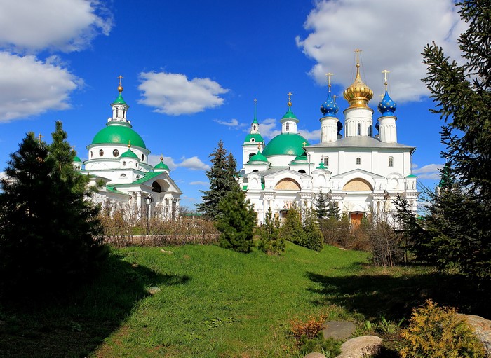 Orthodox churches with green and gold domes under a blue sky