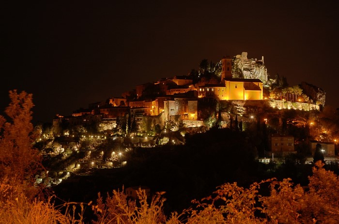 Illuminated medieval village on a hill at night