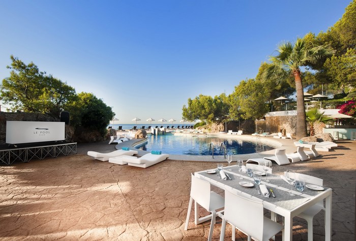 Le Pool Club resort with swimming pool and dining table