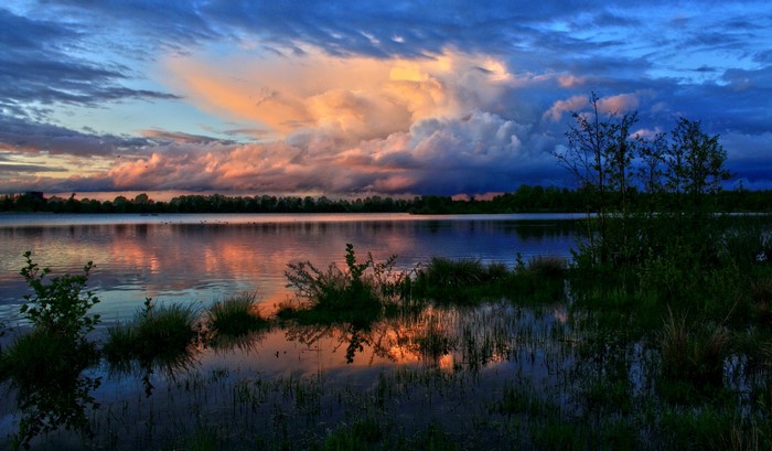 Sunset over a lake with dramatic clouds in Laupheim, Germany