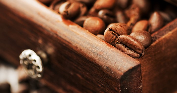 Coffee beans in a wooden grinder