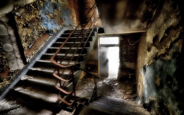 Abandoned staircase with peeling paint and debris