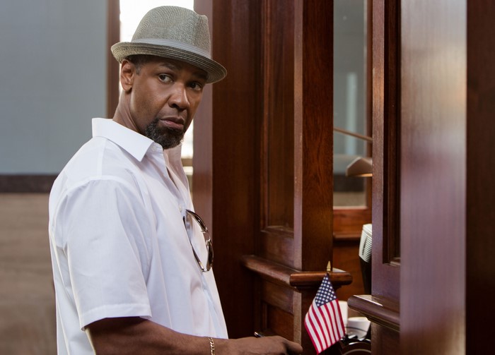 Denzel Washington wearing a hat and white shirt