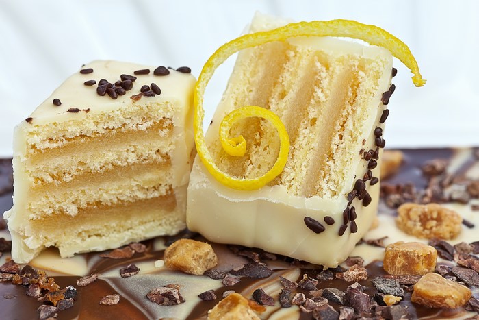 Two slices of white chocolate cake with chocolate shavings