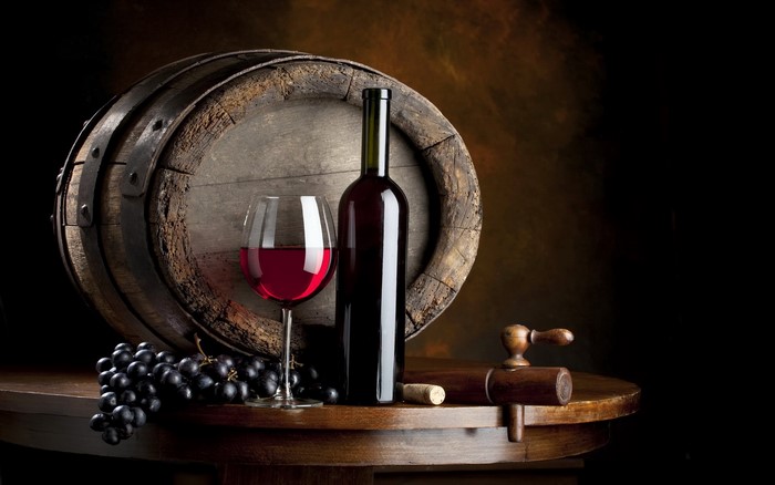 Wine bottle, glass, grapes, and barrel