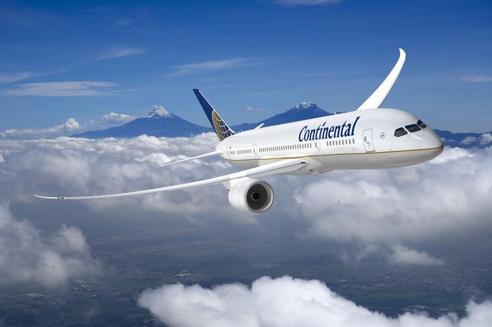 Continental Airplane Flying Above Clouds and Mountains