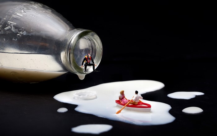 Miniature figures in a spilled milk bottle and boat
