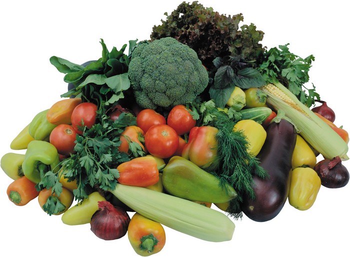 A large pile of fresh vegetables including tomatoes, broccoli, bell peppers, eggplant, corn, and onions.