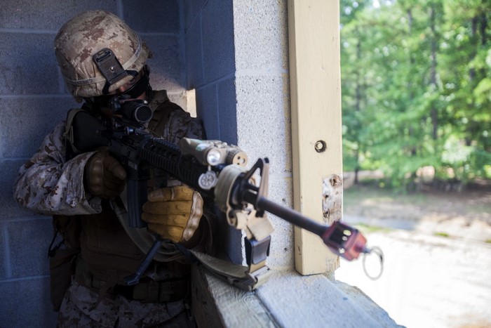 Soldier aiming an assault rifle from cover