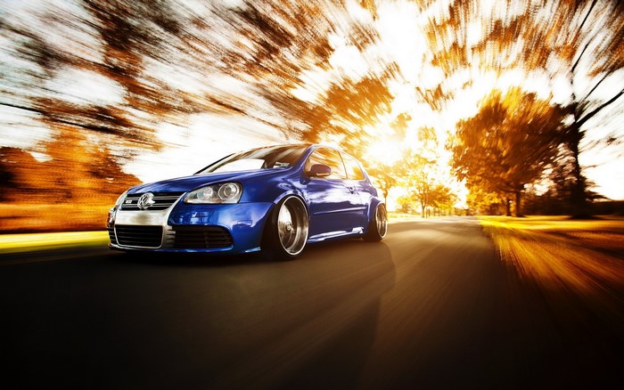 Blue Volkswagen Golf R32 driving on a road