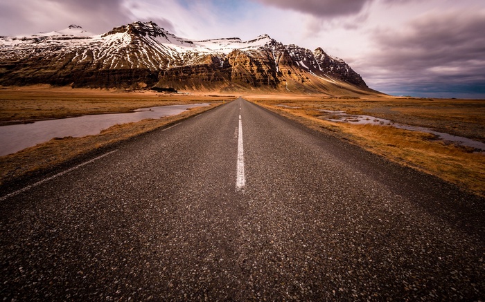 Road leading to snow-capped mountains in Iceland