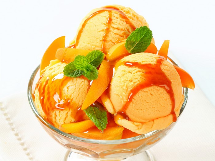 Orange ice cream sundae with fruit and mint