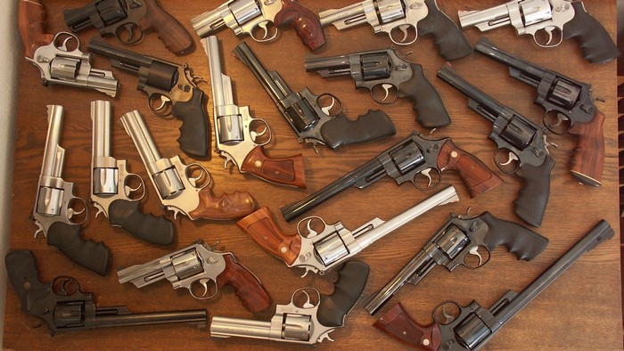 Many revolvers on a wooden surface