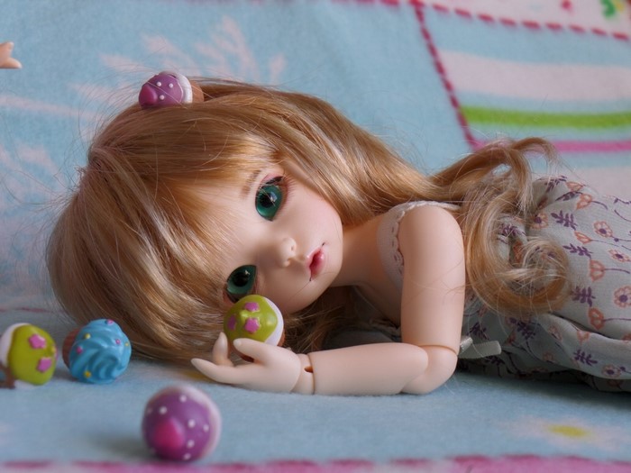 Doll with blonde hair and green eyes lying down