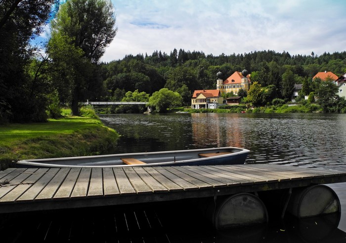 Boat docked on a wooden pier with a castle in the background