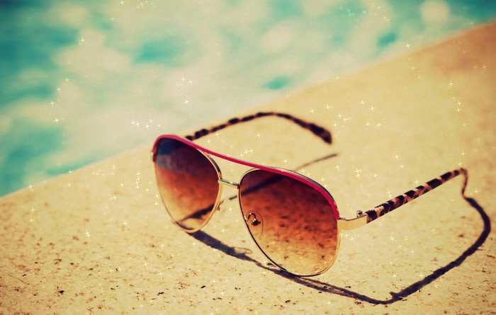 Aviator sunglasses with leopard print arms by a pool