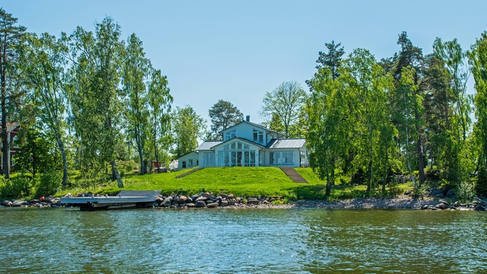 Modern house on a grassy hill by the water in Vaxholm, Sweden