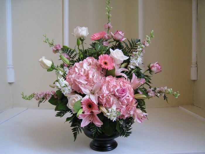 Pink and white floral arrangement with roses, lilies, and gerberas