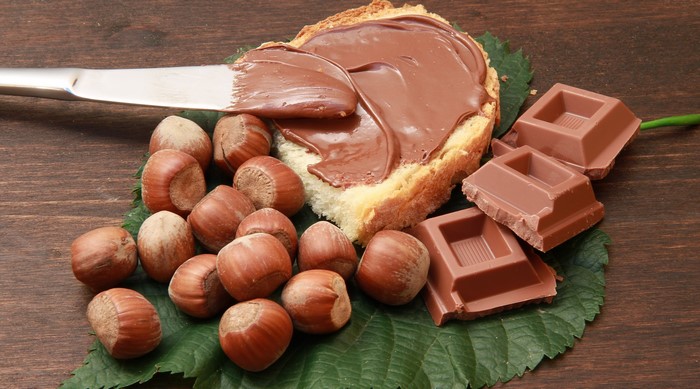 Chocolate spread on bread with hazelnuts and chocolate bars