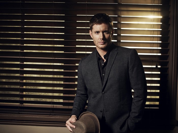 Jensen Ackles in a suit holding a hat