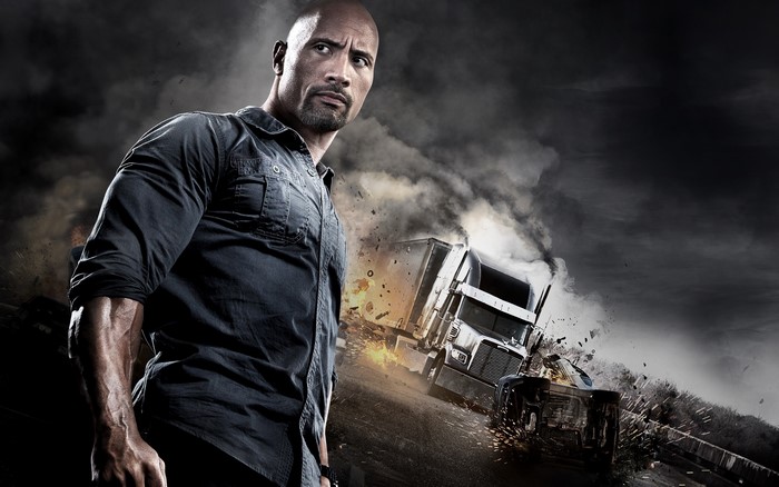 Dwayne Johnson in front of a truck crash