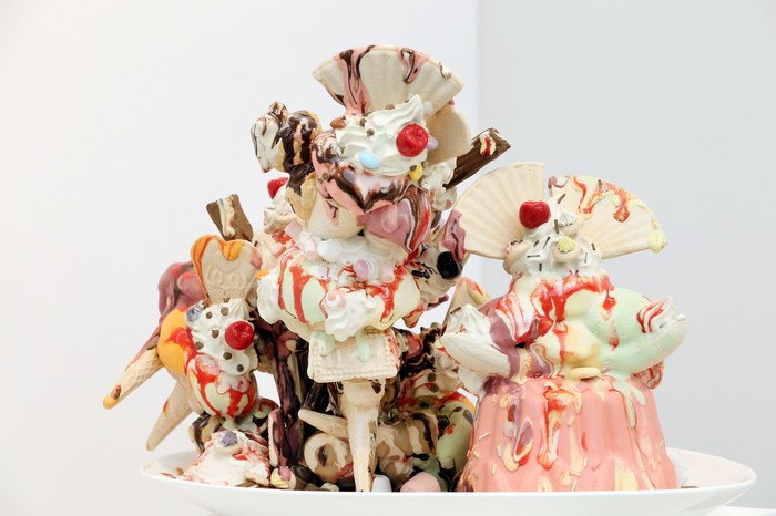 Sculpture of melting ice cream sundaes with cherries and cones