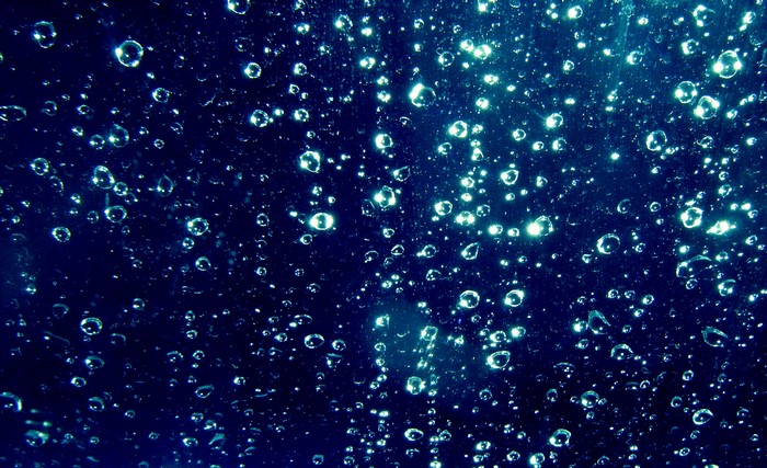 Water drops on dark blue glass surface