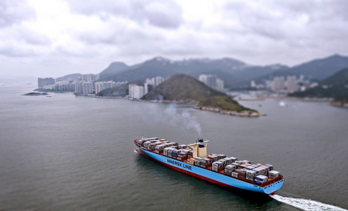 Maersk Line container ship sailing near a coastal city