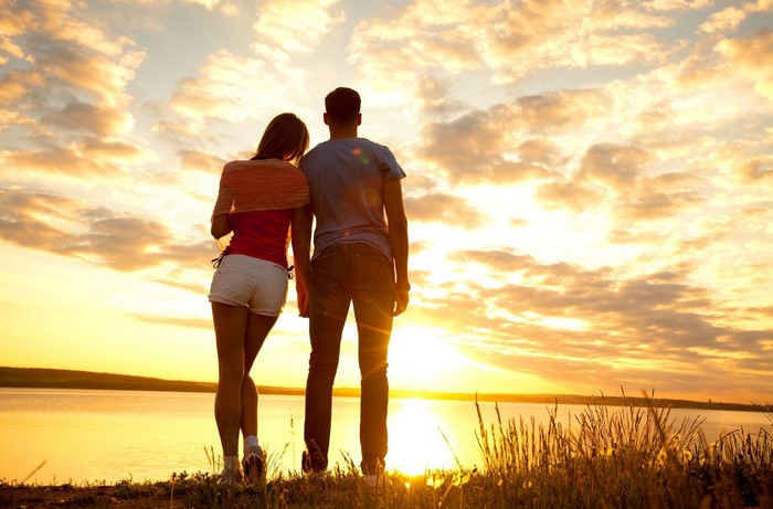 Couple watching sunset over water