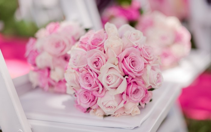 Pink and white rose bouquets on a white surface