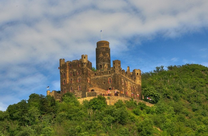Burg Maus castle on a green hill under a blue sky