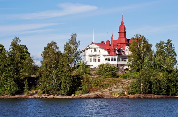 White building with red roof on an island in Finland