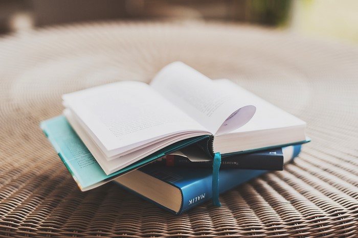 Stack of books on a woven surface