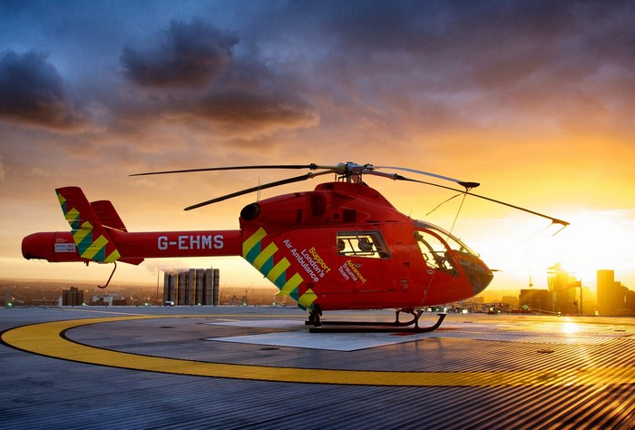 Red London Air Ambulance Helicopter on Helipad at Sunset