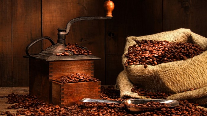 Antique coffee grinder with coffee beans and burlap sack