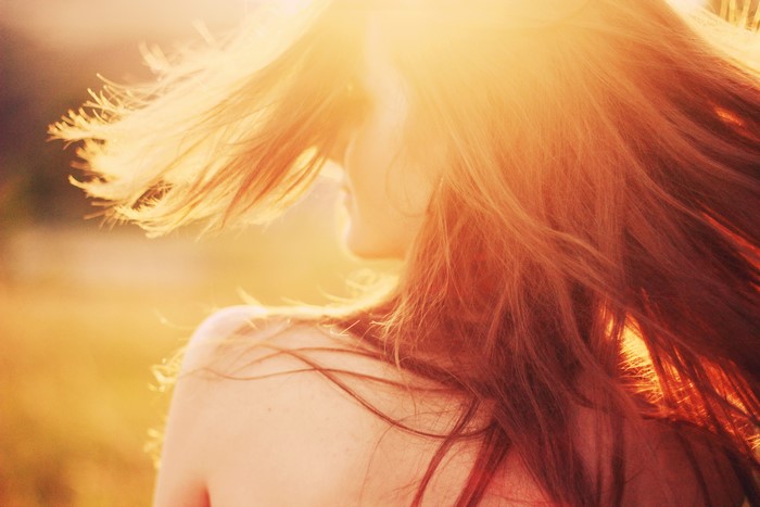 Woman with flowing brown hair in sunlight