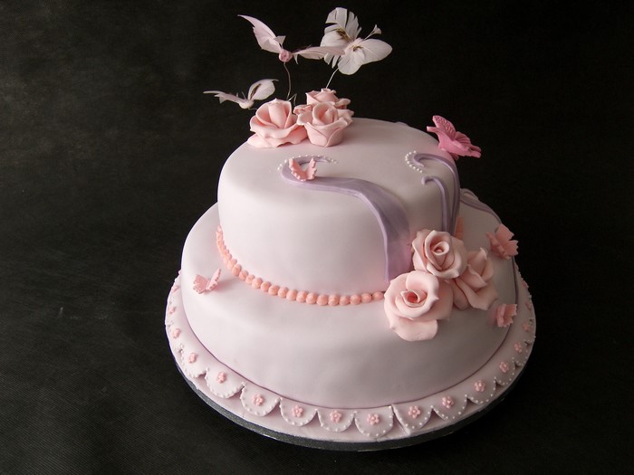 Two-tier pink cake with roses and butterflies